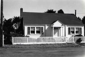 A small house with a fence in front of it