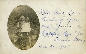 An oval portrait of two young children with handwritten note dated to December 30, 1915 saying "Happy New Year" beside the photo