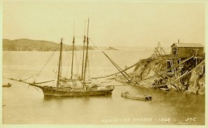 Schooner in a harbor with small boat nearby