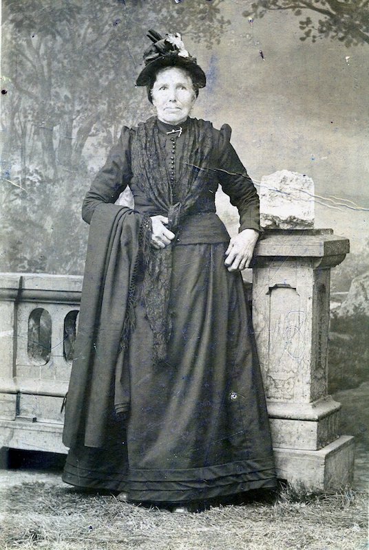 Studio Portrait of woman, standing, in a long skirt and fashionable hat