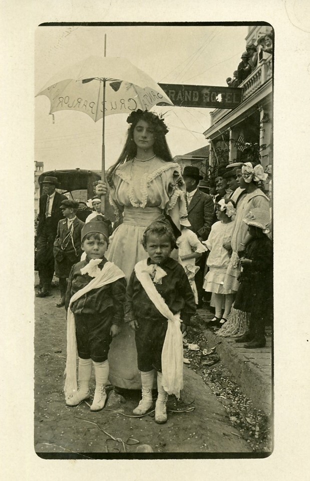 vintage black and white photo showing victorian lady with parasol behind two small children