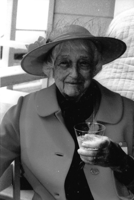 Lady in hat, with glass in hand