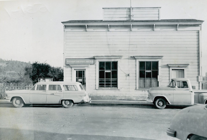 Station Wagon and Truck parked in front of historical commercial building
