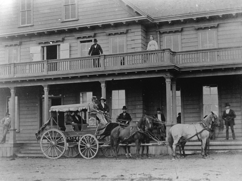 Stage Coach in front of three story hotel with veranda