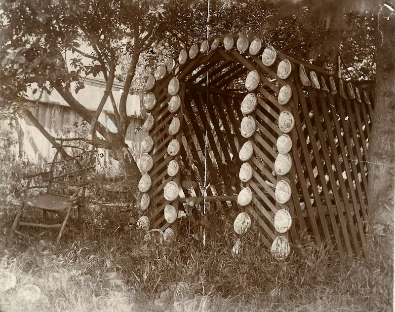 Arbor made out of lattice work with abalone shells decorating the front