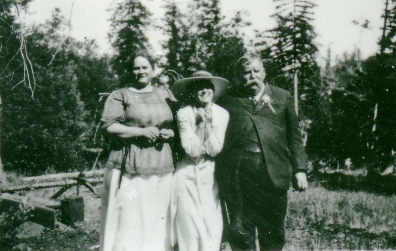 Woman stands between her mother and father