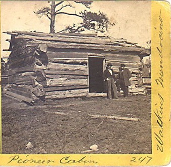 Two men standing in front of rustic cabin